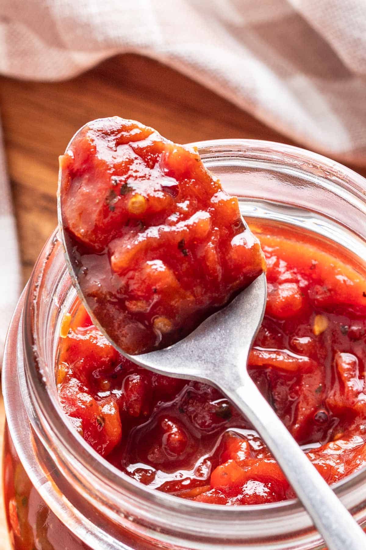 A spoon with tomato jam on it.
