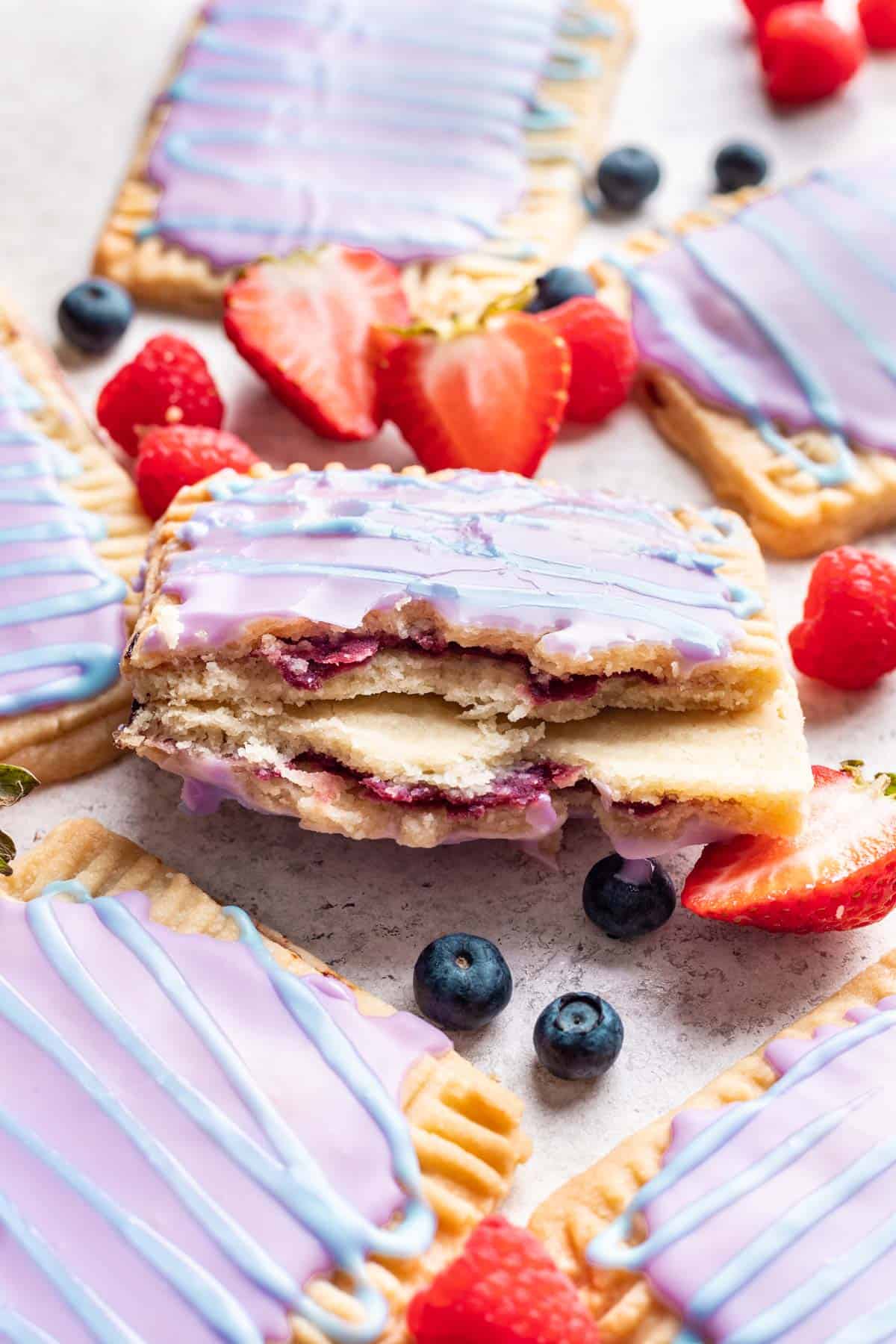 A homemade wild berry pop tart broken in half to show the berry filling.
