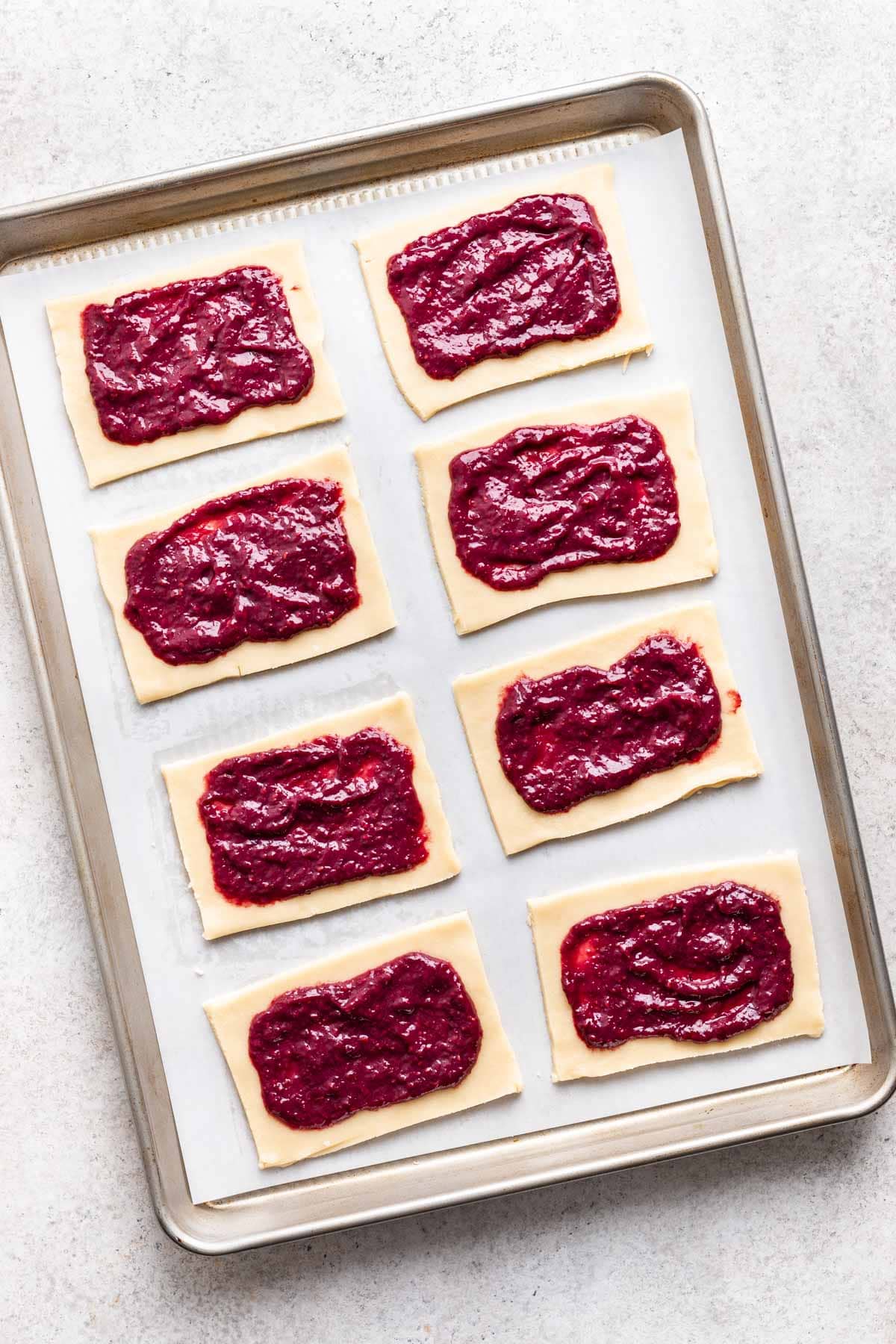 Rectangles of shortbread dough with wild berry filling in the center of each one.