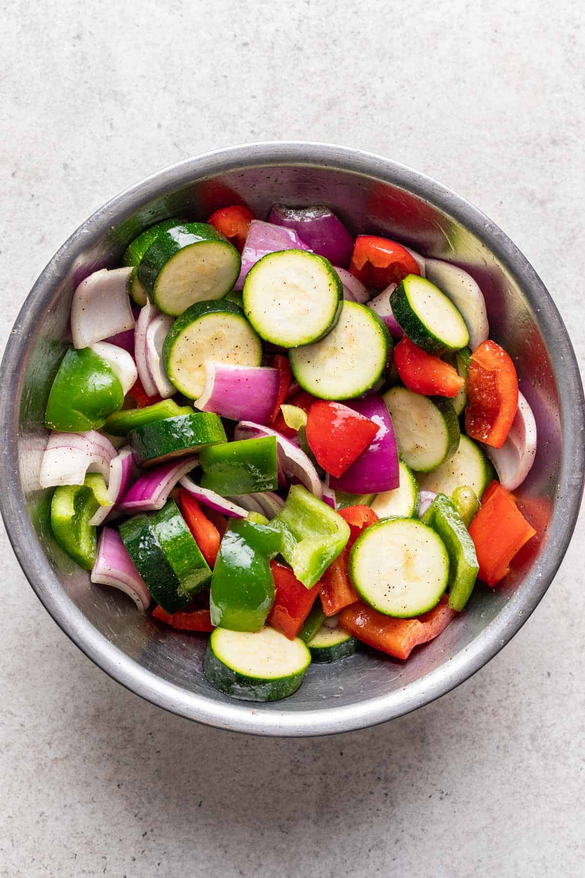 Cut veggies in a mixing bowl with oil, salt, and pepper.