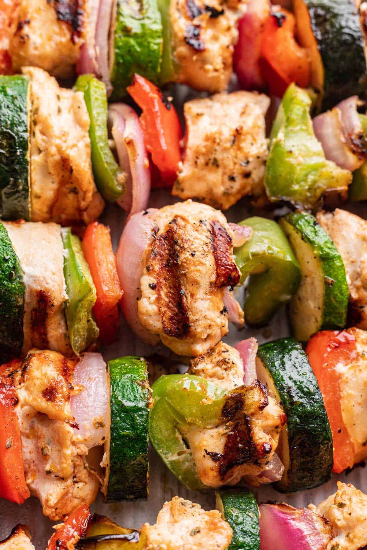 Closeup of yogurt marinated chicken skewers to show grill marks on the chicken.