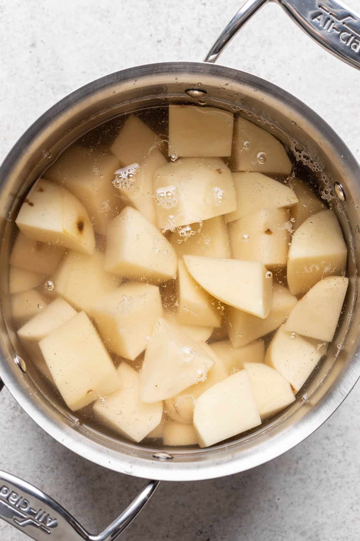 Potatoes boiling in a large pot.