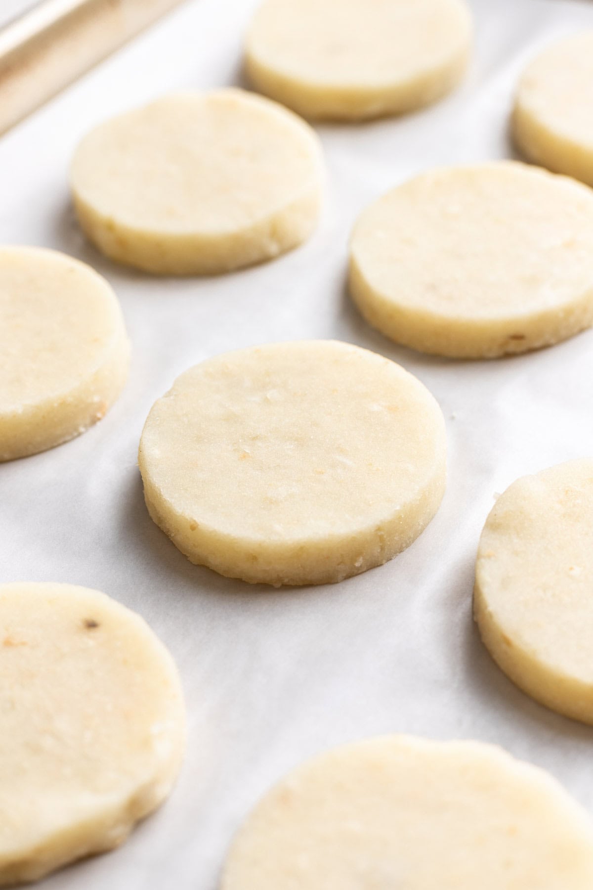 Smiley potato dough cut into thick rounds and placed on a baking sheet.