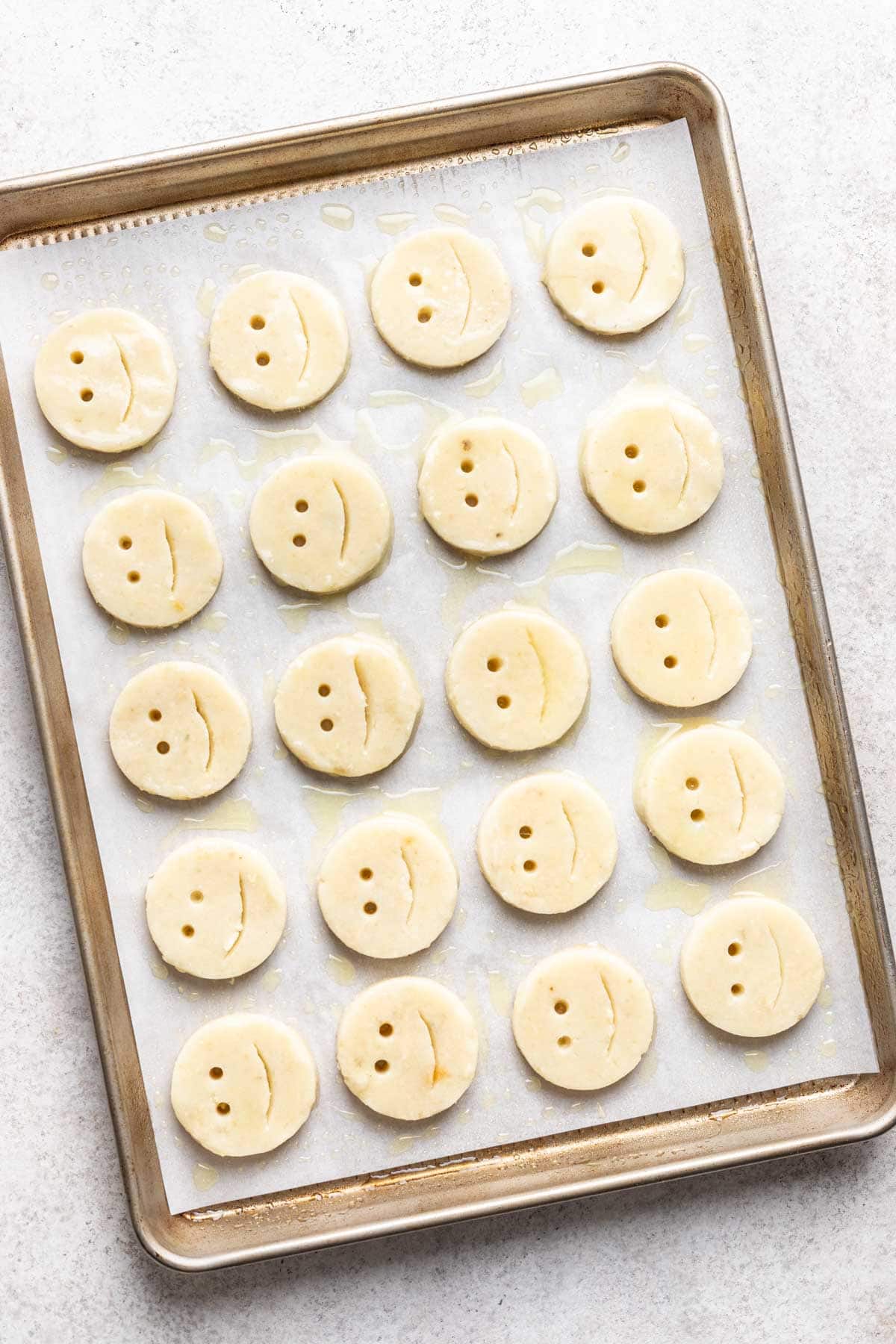 Smiley potatoes on a baking sheet prior to baking.
