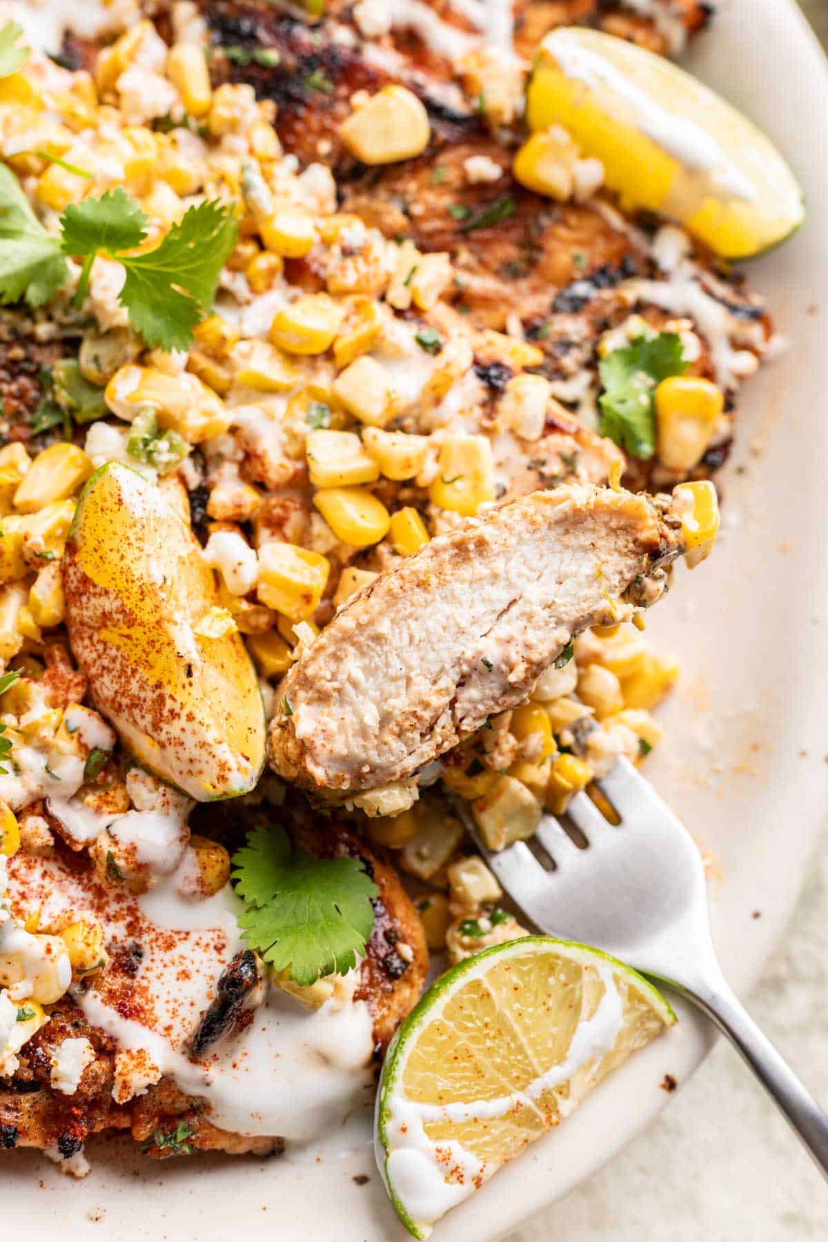 A sliced piece of street corn grilled chicken to show how tender and juicy it is.