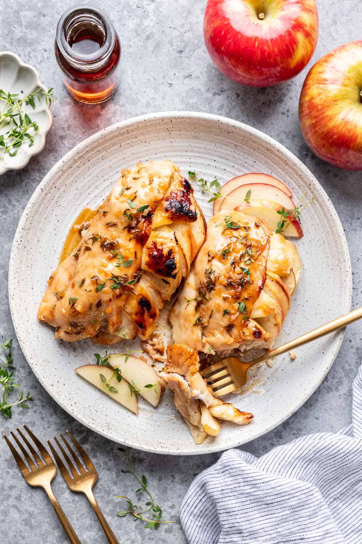 Apple and brie stuffed chicken with a gold fork on the plate.