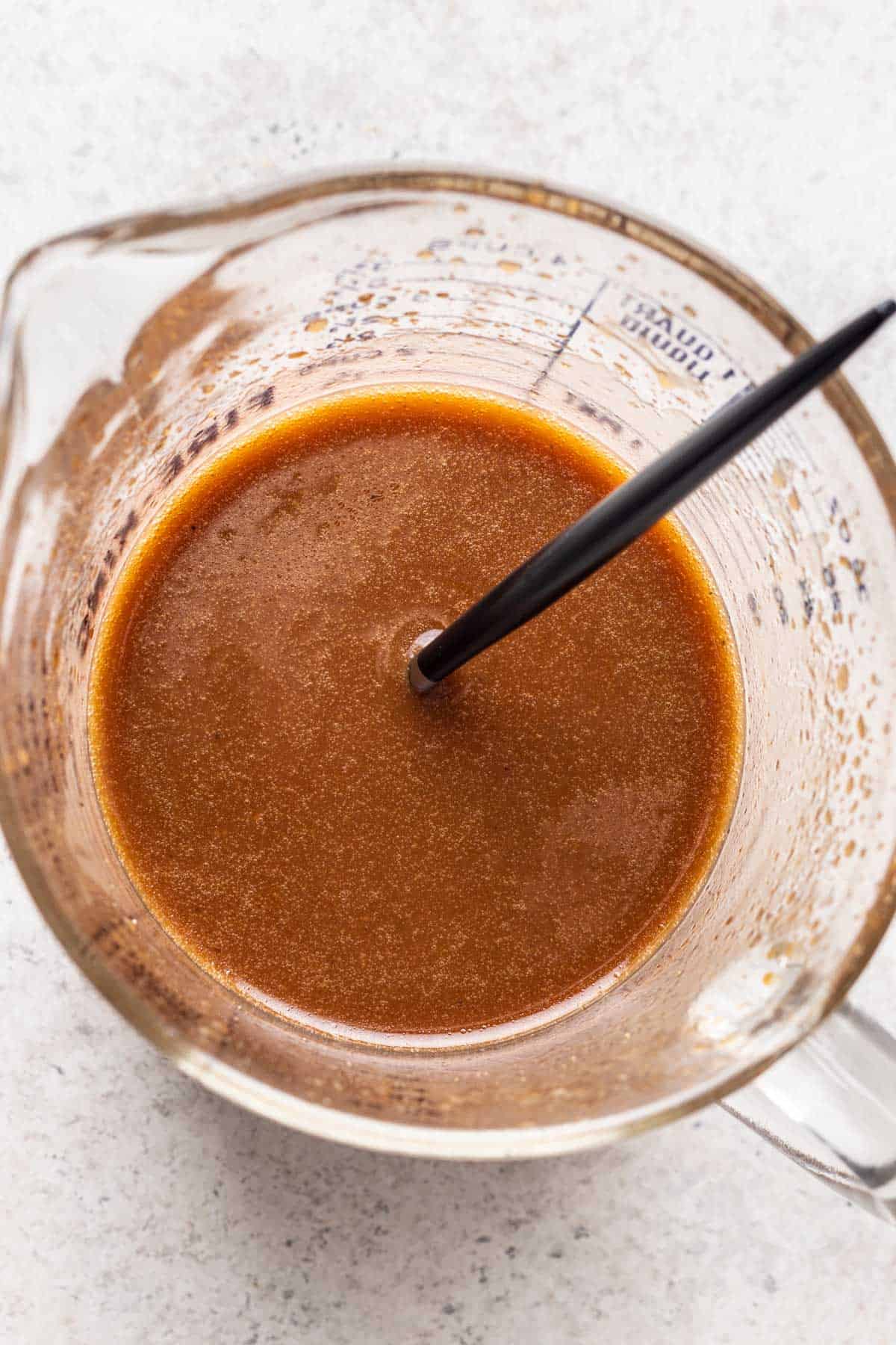 Maple balsamic dressing mixed in a measuring glass.