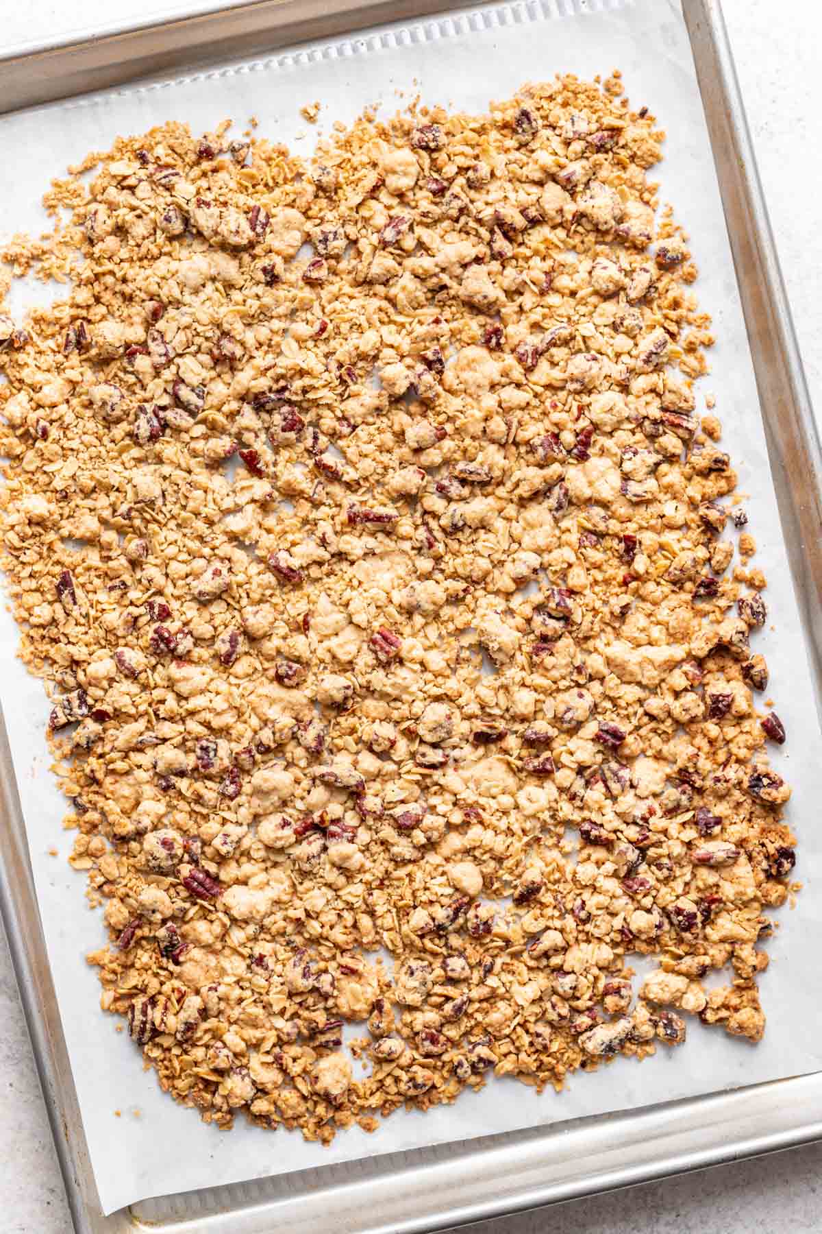 Golden brown savory apple crisp topping on a baking sheet.