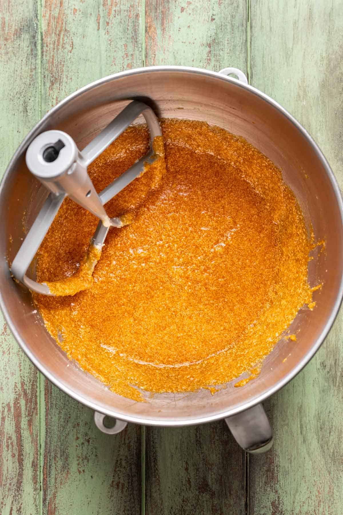 Eggs, pumpkin, and vanilla extract added to the butter and sugar in a bowl.