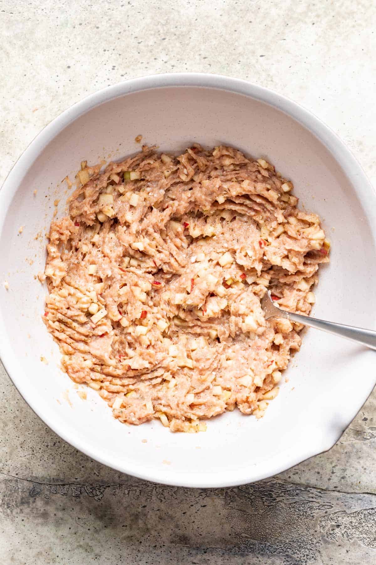 Ingredients for chicken and apple breakfast sausage mixed in a bowl.