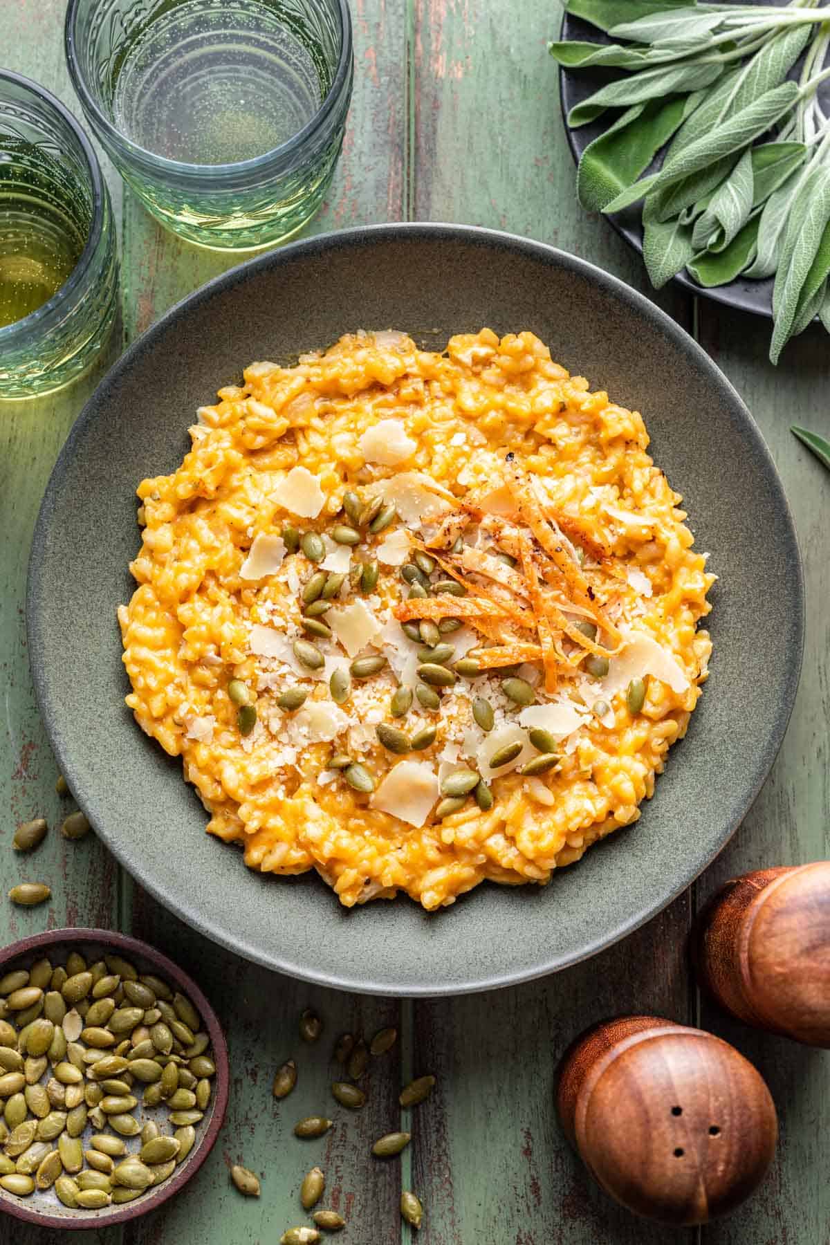 Creamy, orange chicken and pumpkin risotto in a green bowl.