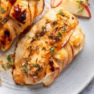 Apple and brie stuffed chicken with fresh thyme and maple glaze on top.