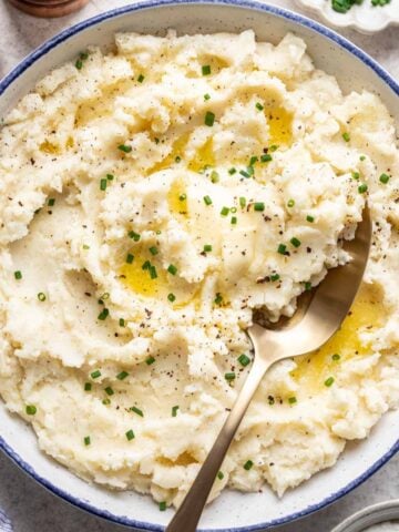 Greek yogurt mashed potatoes in a bowl with a serving spoon.