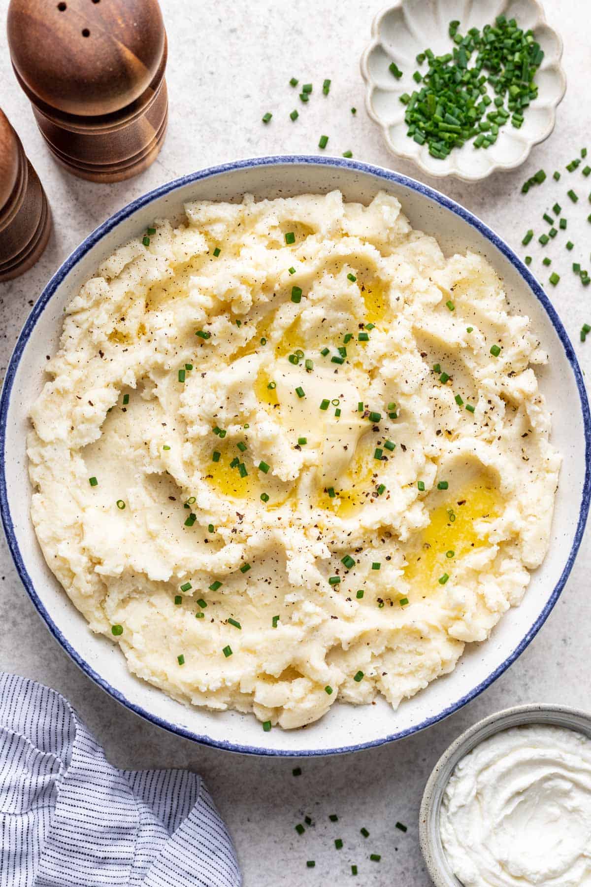 Greek yogurt mashed potatoes in a serving bowl with a blue rim.