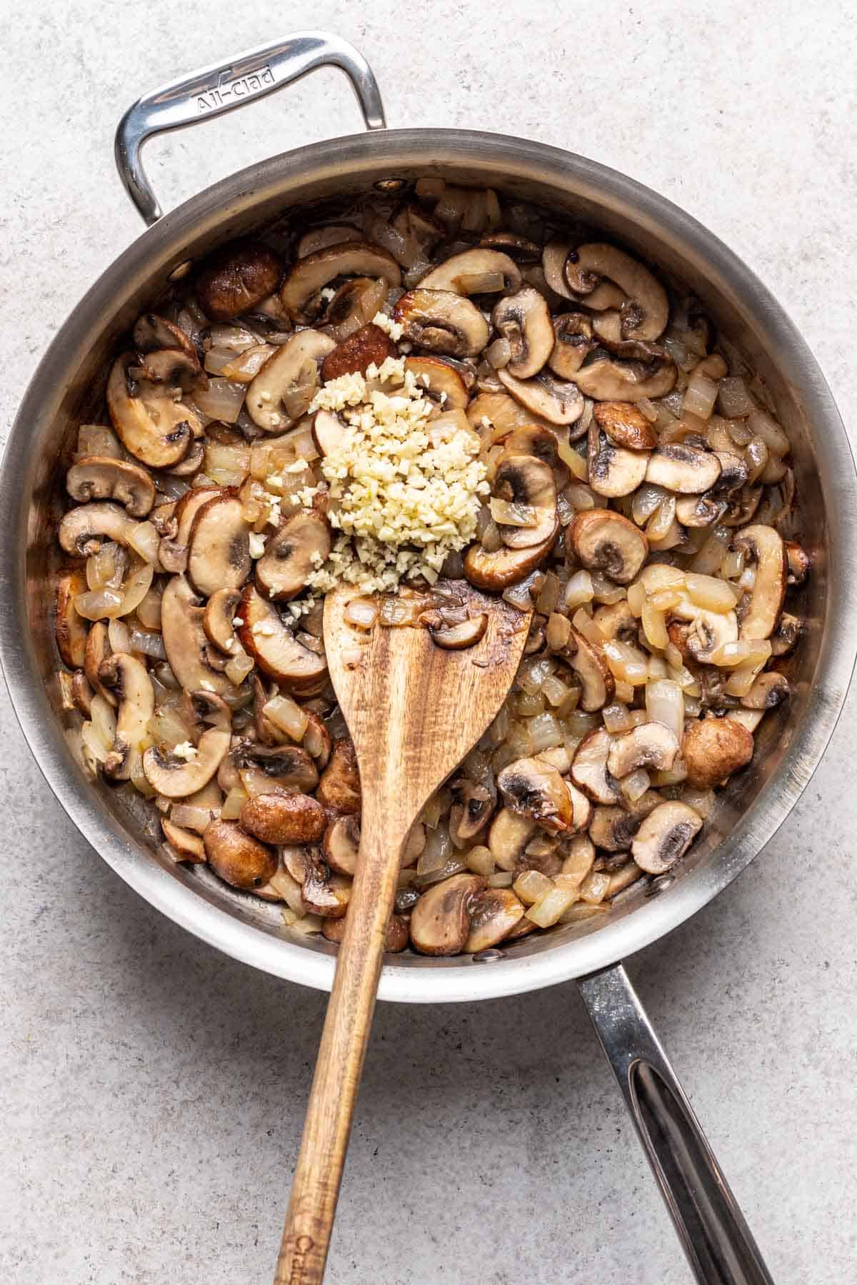 Garlic added to the skillet with the mushrooms and onions.
