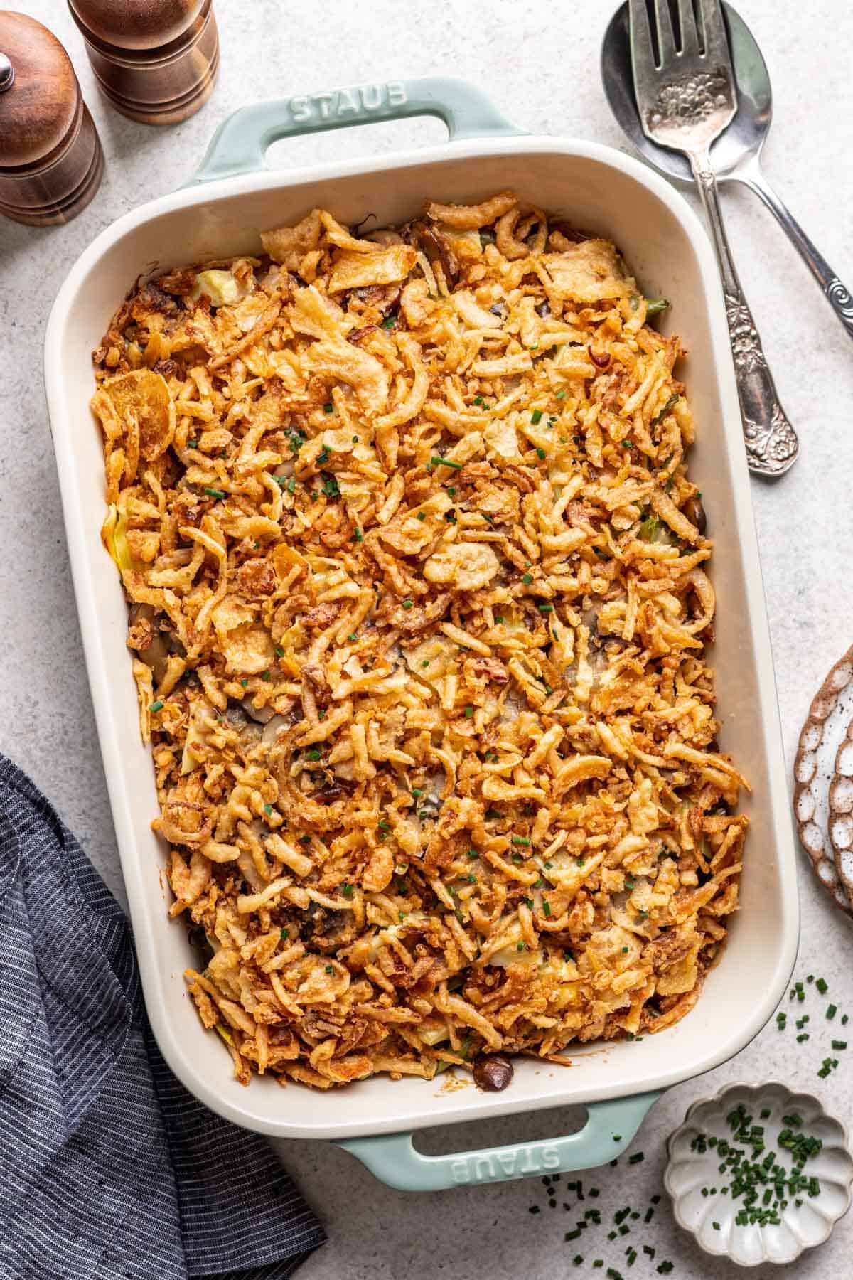 Green bean and artichoke casserole in a baking dish, topped with fried onions.