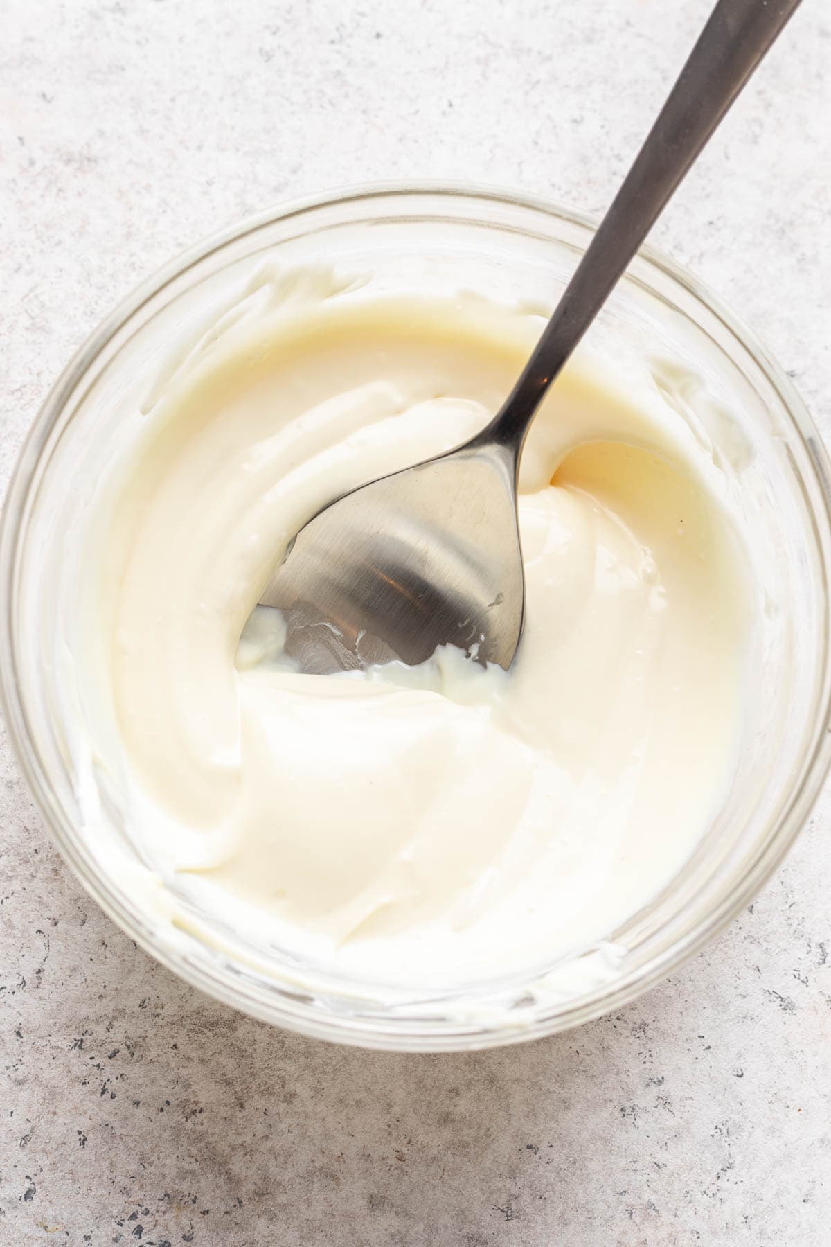 Melted white chocolate in a glass bowl.