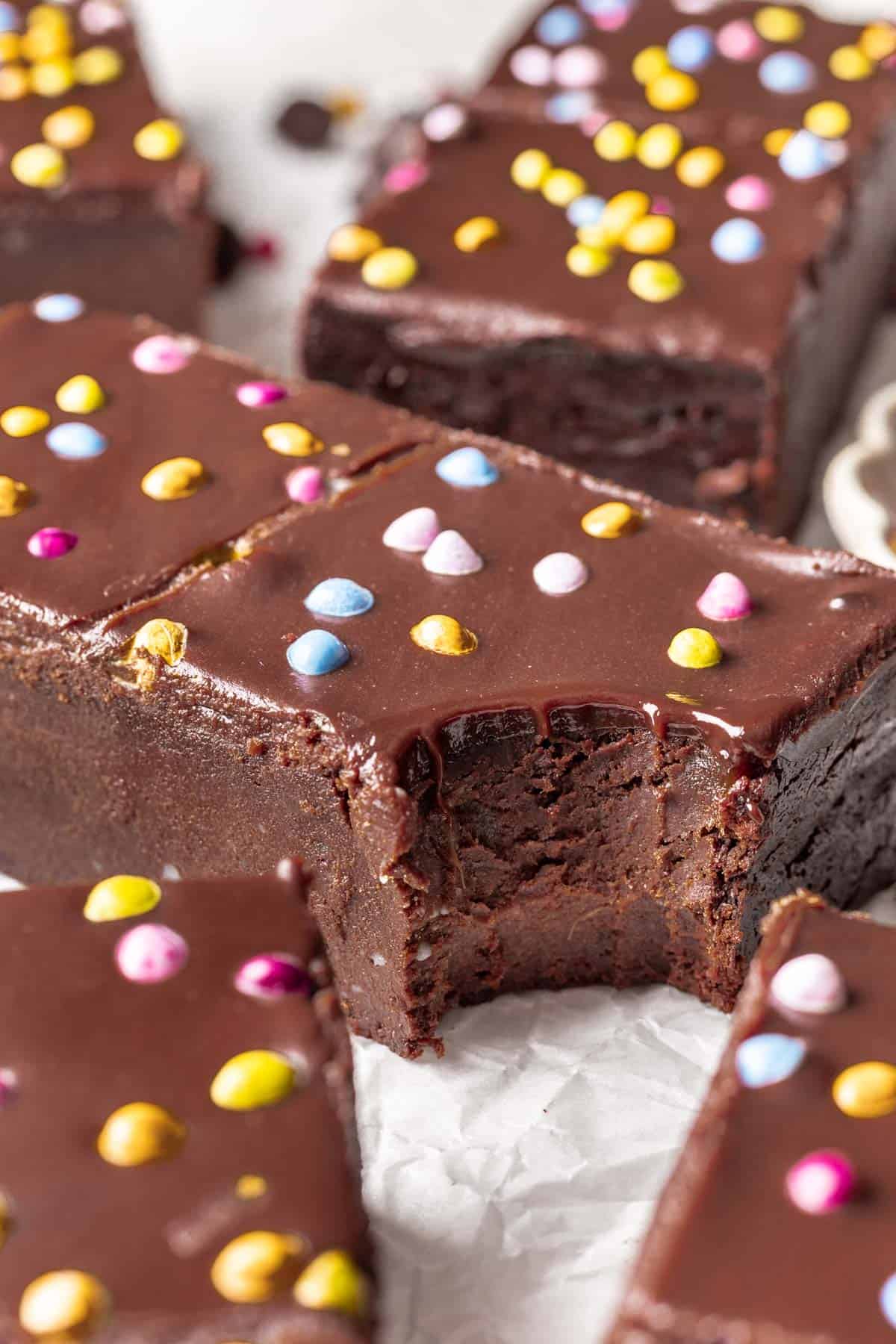 A bite taken out of a healthier cosmic brownie to show it's fudgy texture.