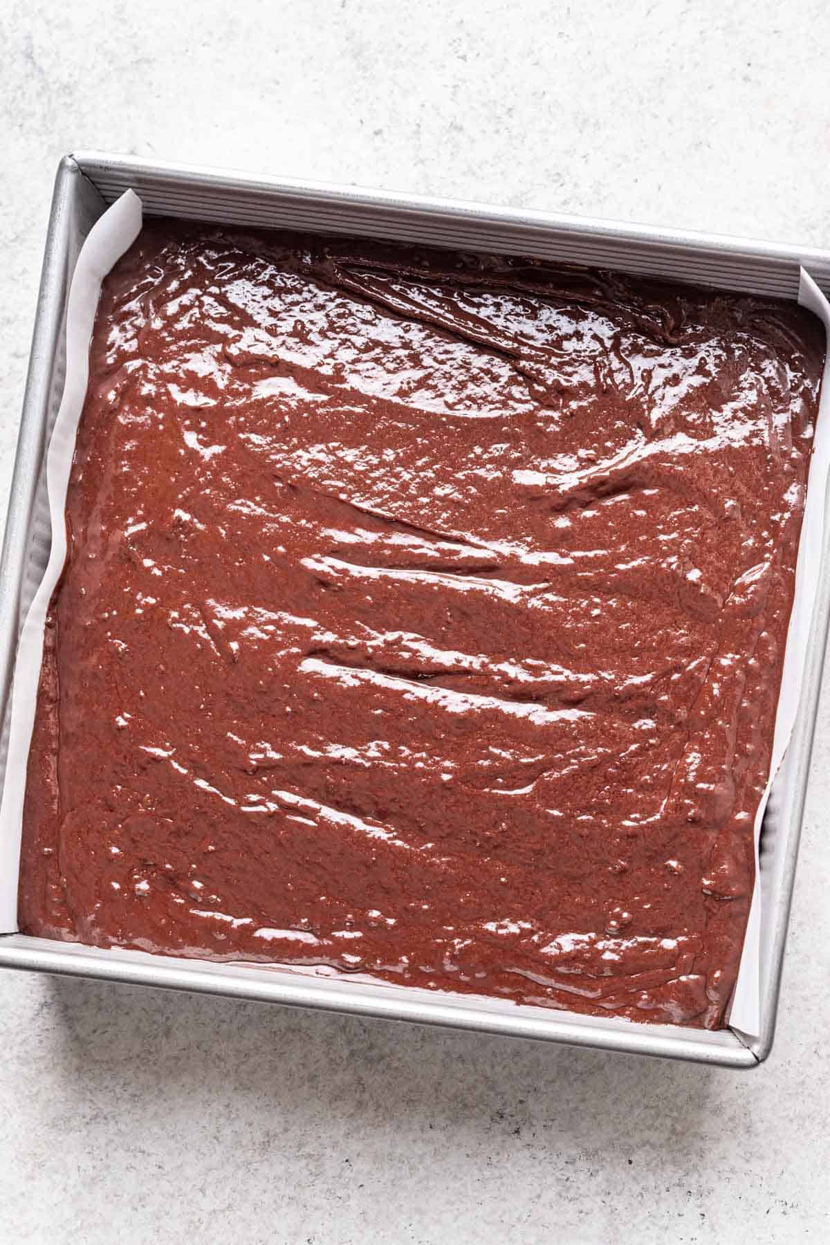 Brownie batter in a pan before baking.