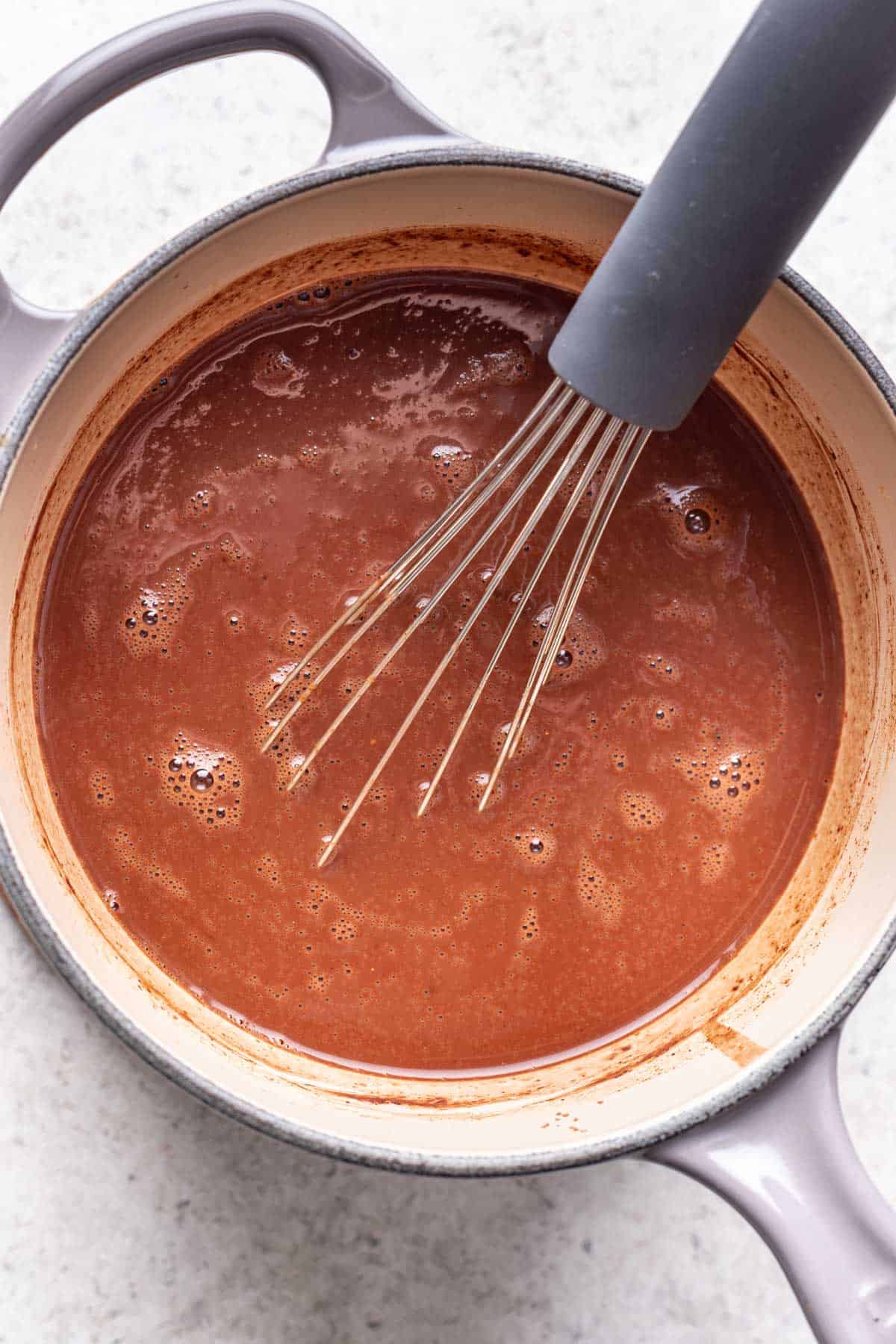 Cocoa powder and seasonings added to the milk in a saucepan.