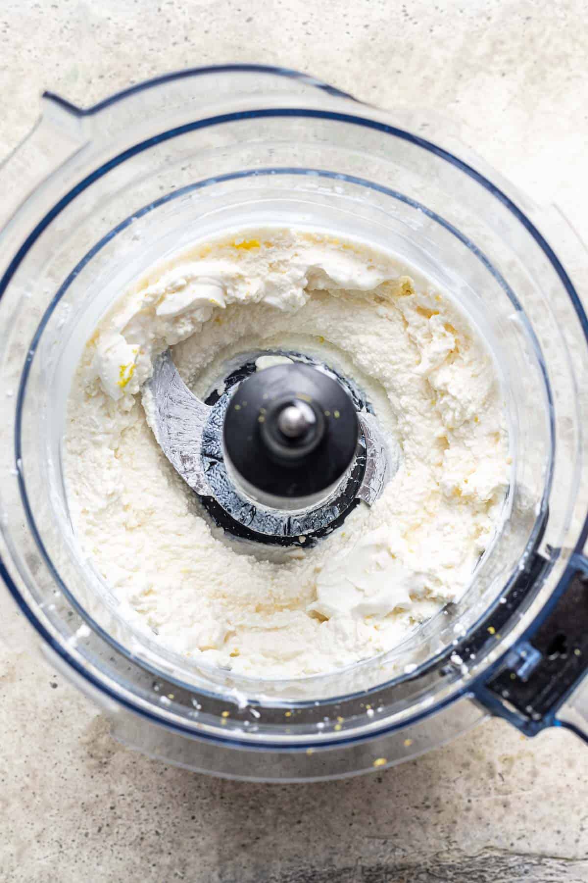 Feta, labneh, and lemon zest added to a food processor.