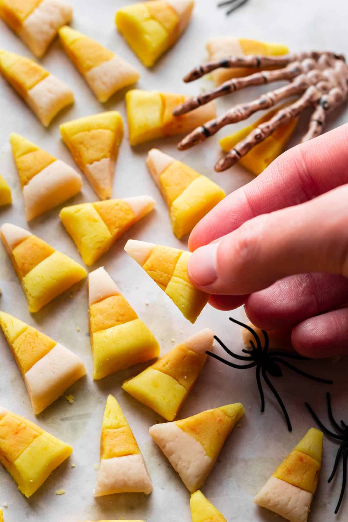 A hand grabbing a piece of homemade candy corn.