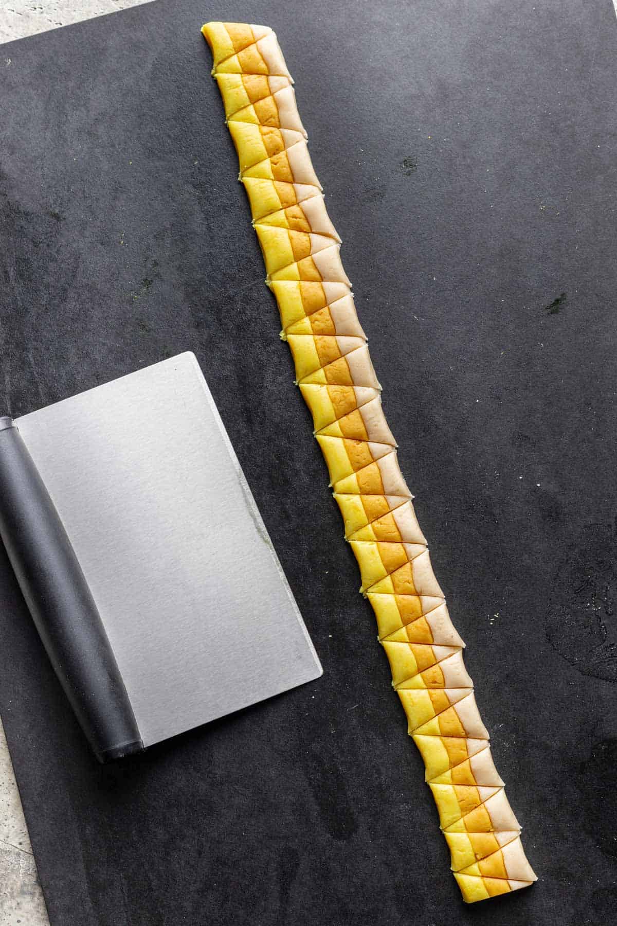 Strip of candy corn cut into triangles using a bench scraper.