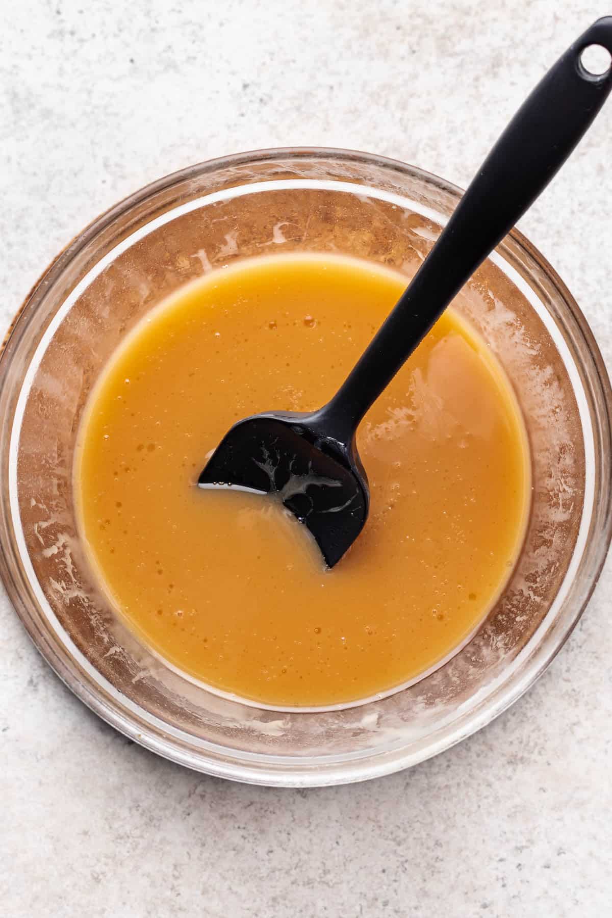 Sweetened condensed milk microwaved in a bowl to create caramel.
