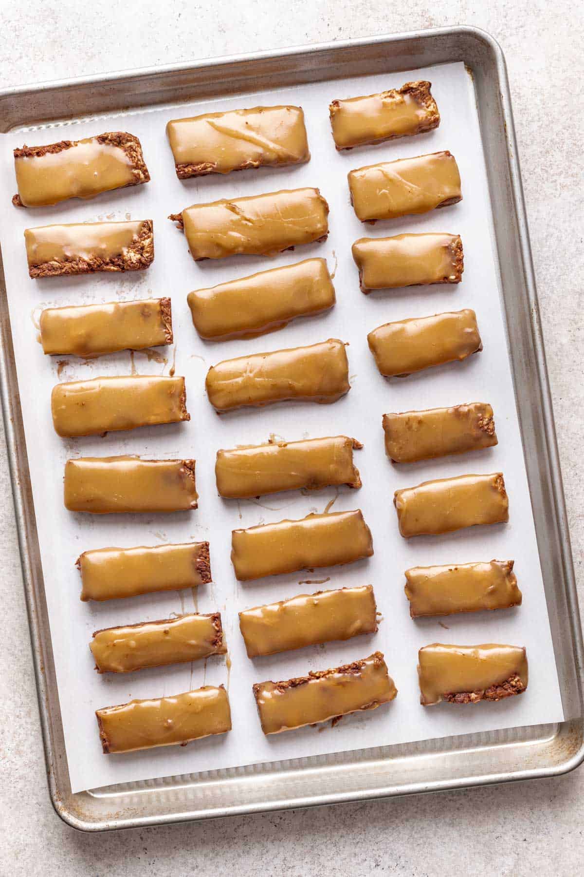 Homemade nougat and caramel cut into bars on a baking sheet.