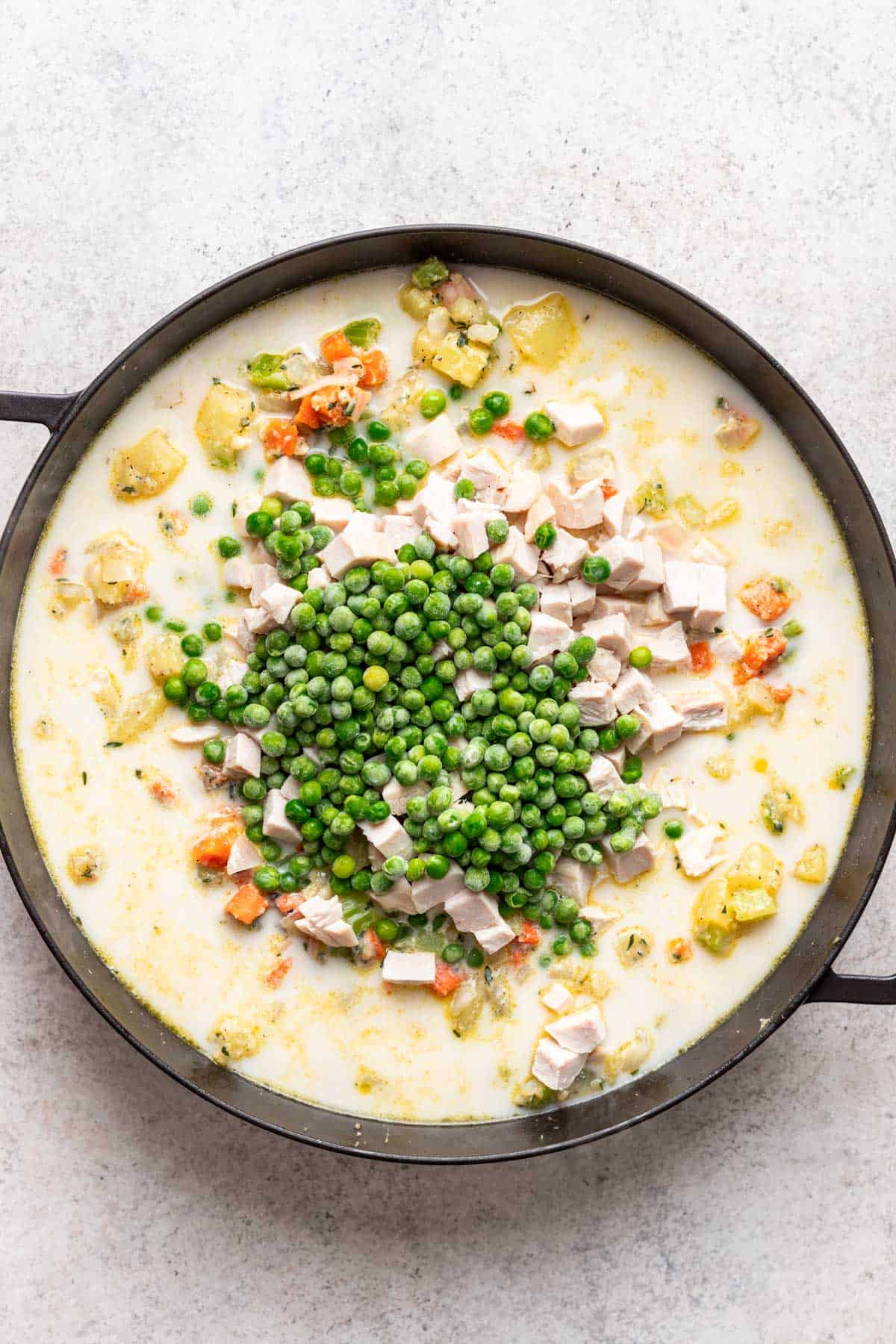 Liquid ingredients, peas, and chicken added to the skillet with the rest of the veggies.