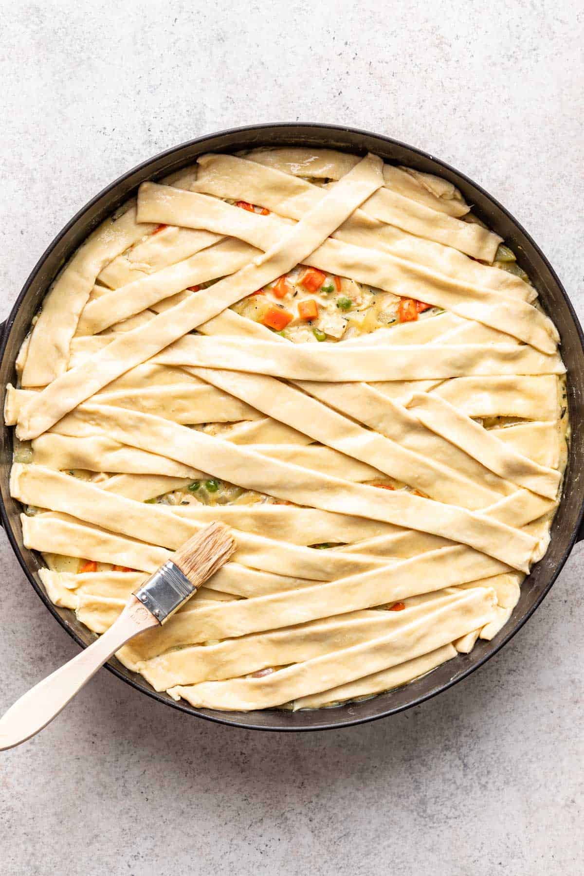 Egg wash brushed on top of the raw puff pastry in the skillet.