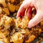 A hand grabbing a piece of savory monkey bread from the rest.