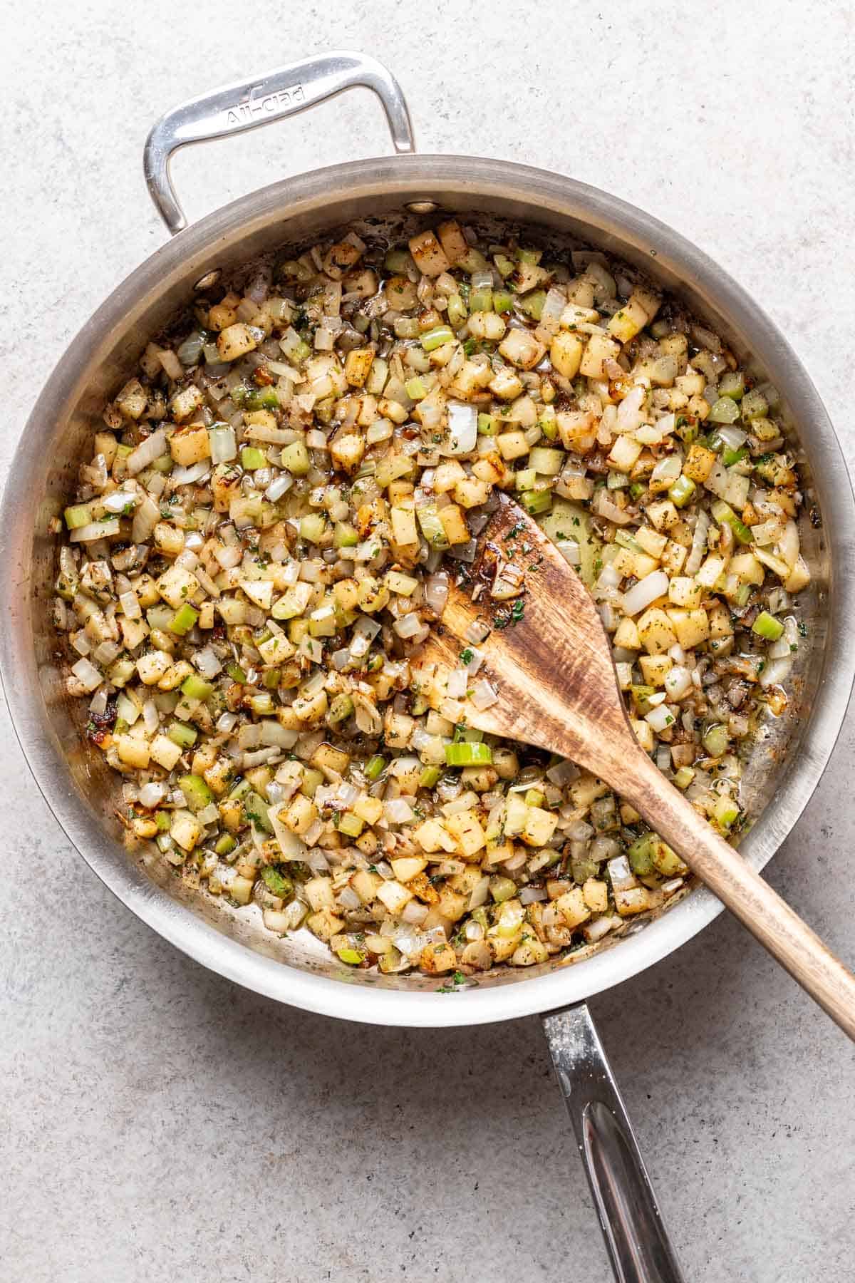 Vegetables and herbs sautéed in a skillet.