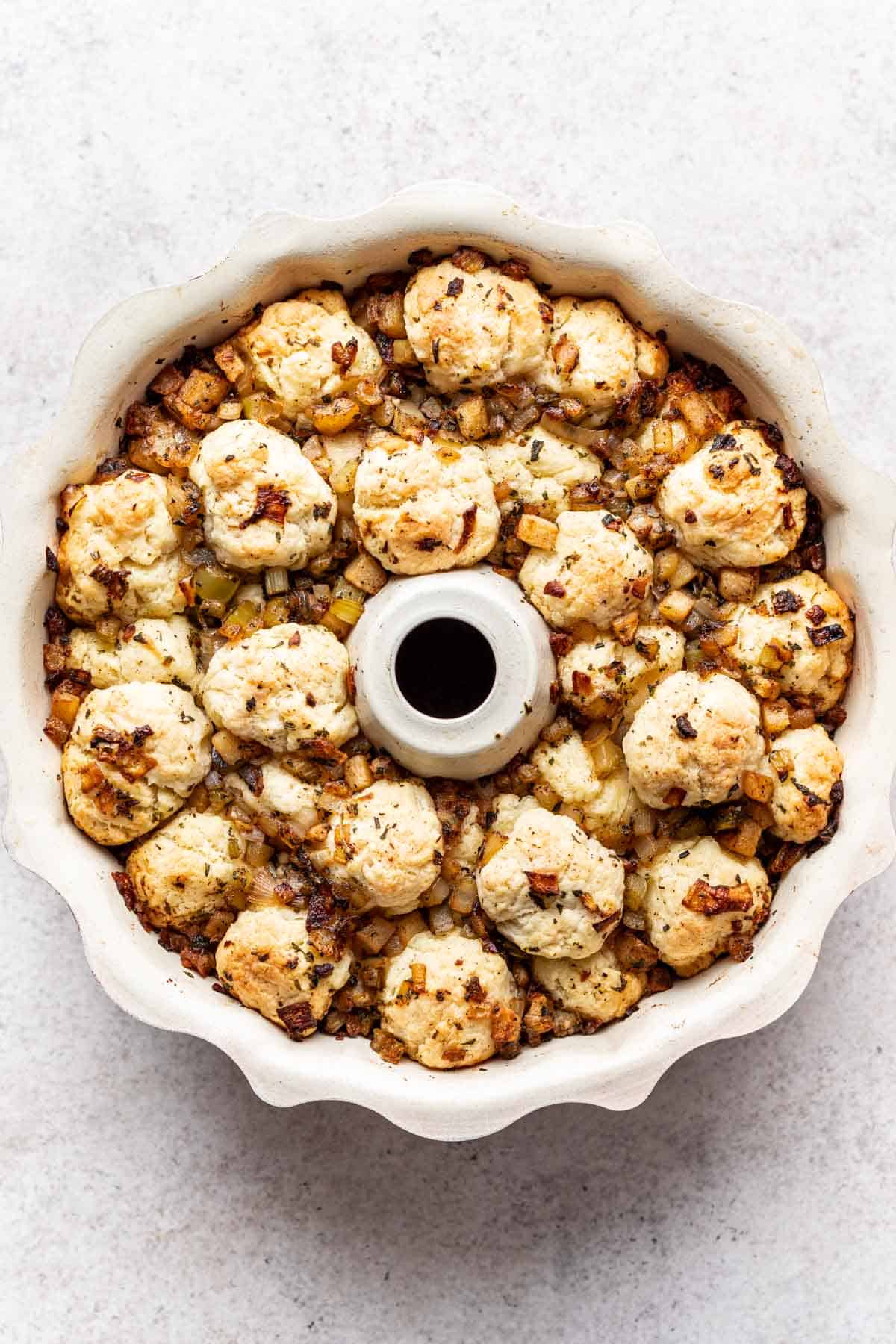 Homemade biscuit dough rolled into balls, layered with stuffing vegetables in a bundt pan filled to the top.