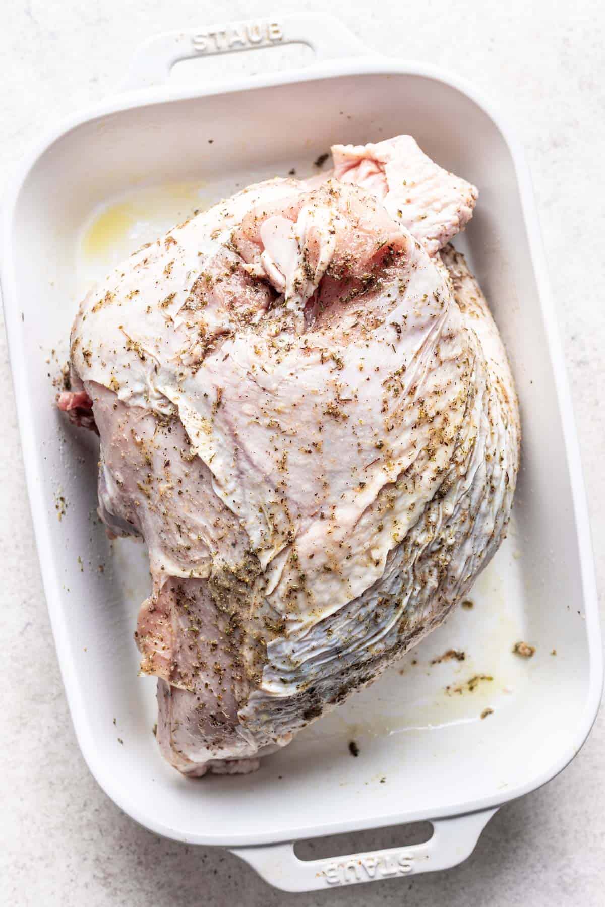 Seasoning and oil mixture rubbed all over the raw turkey breast.