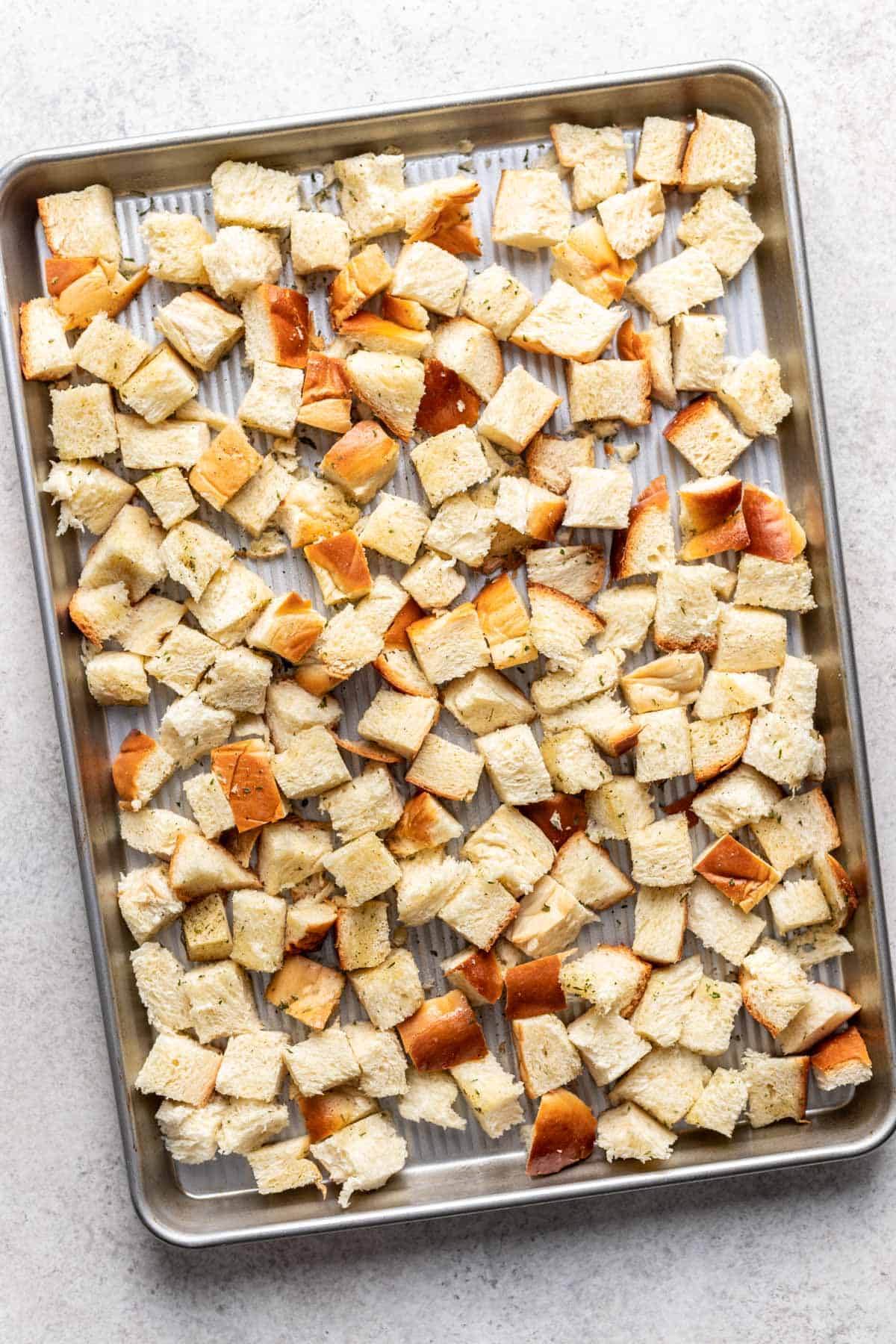 Cubed challah on a large baking sheet.
