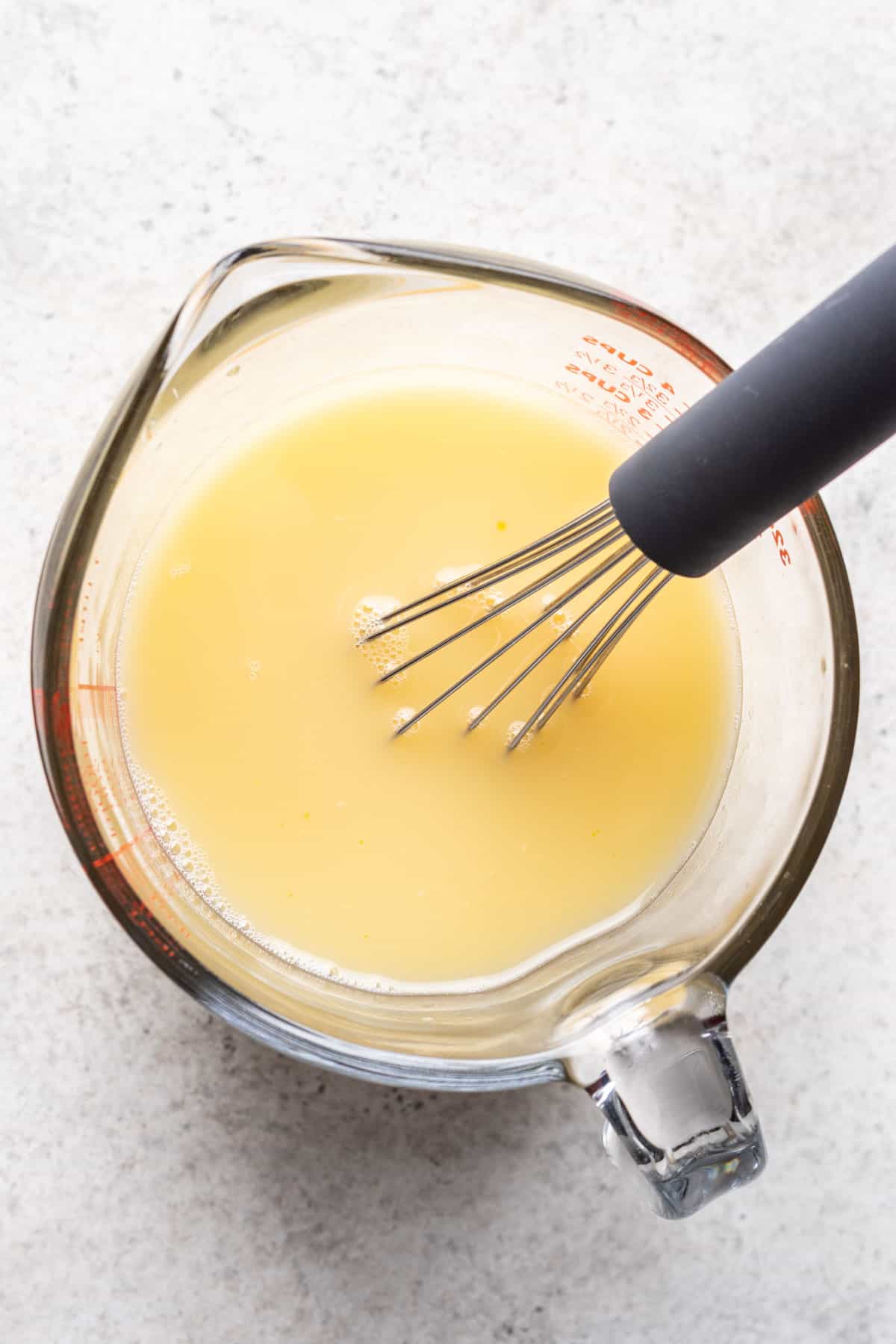Broth and egg whisked in a measuring cup.