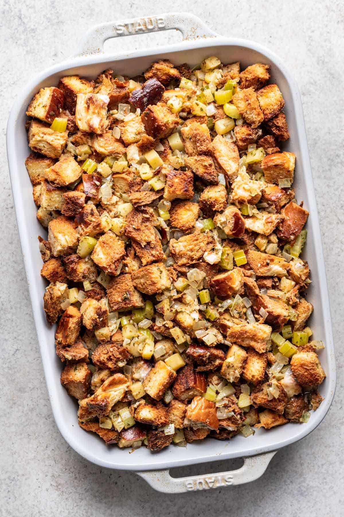 Challah stuffing in a white baking dish before baking.