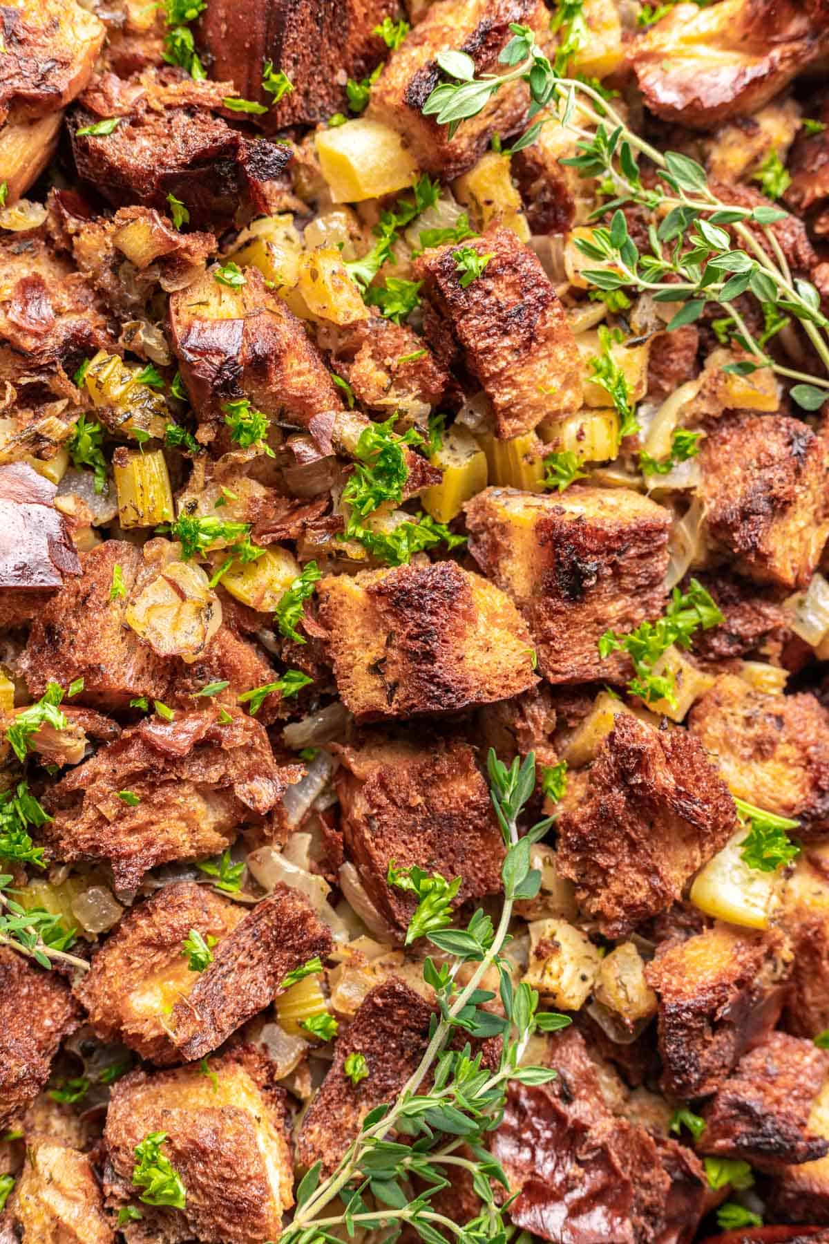 Challah bread stuffing with fresh herbs on top.