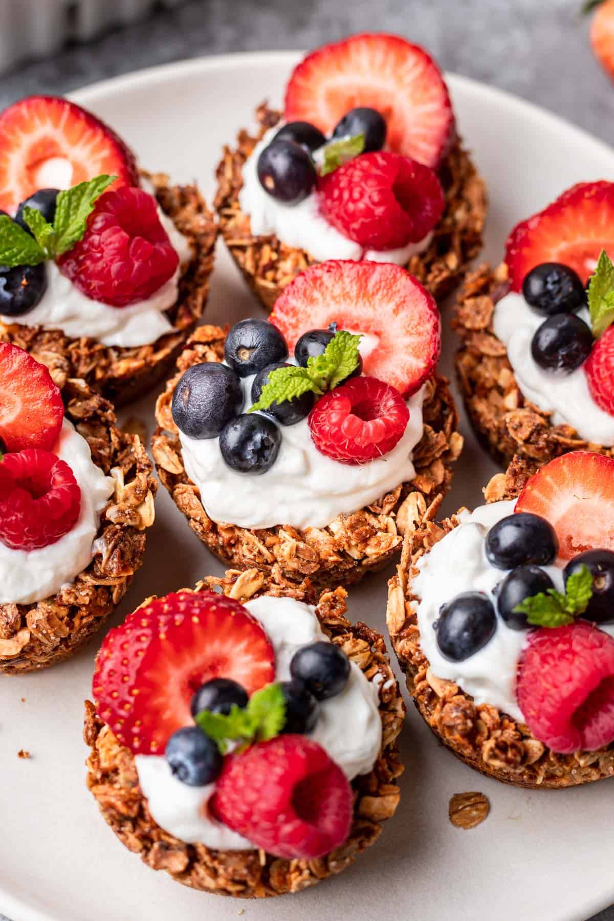 Granola cups topped with yogurt, berries, and mint.