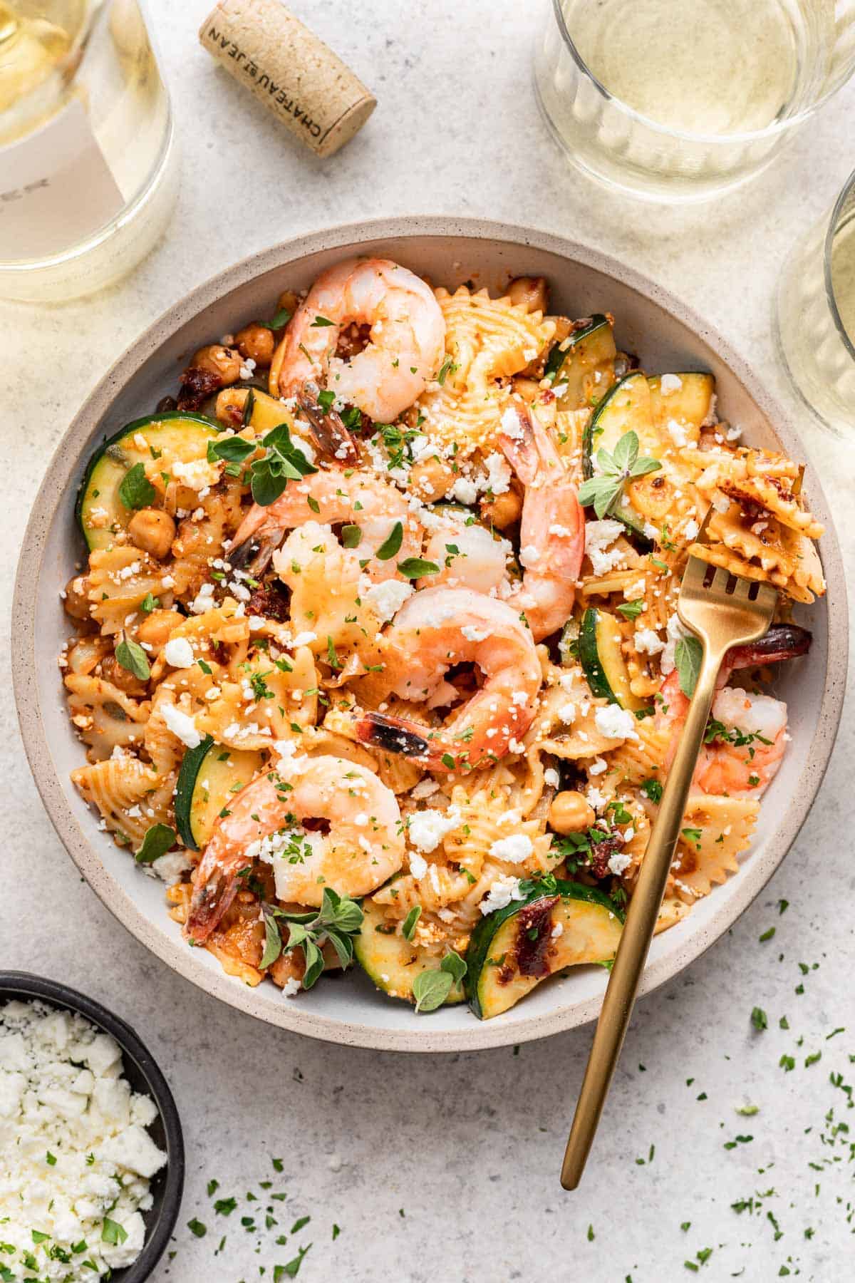 Shrimp and sun dried tomato pasta in a bowl with a fork.
