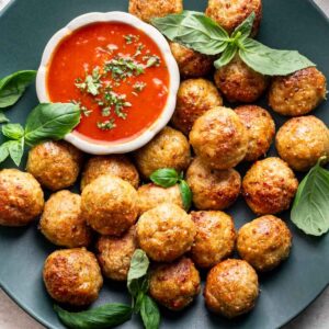 Air fryer chicken meatballs on a green serving platter.