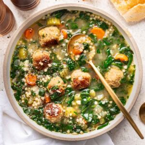 Instant pot Italian wedding soup in a white bowl with a spoon.