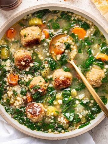 Instant pot Italian wedding soup in a white bowl with a spoon.
