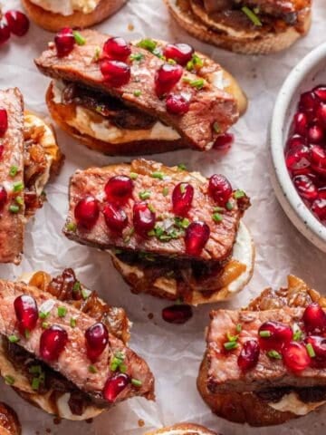 Steak and whipped feta crostini topped with fresh chives and pomegranate seeds.