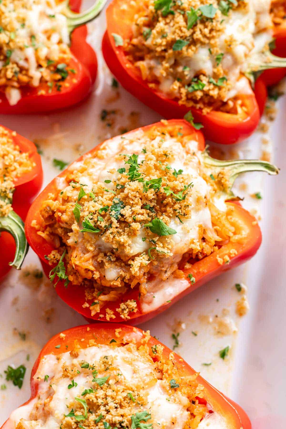 Chicken parmesan stuffed peppers with sauce, rice, cheese, and a breadcrumb topping.