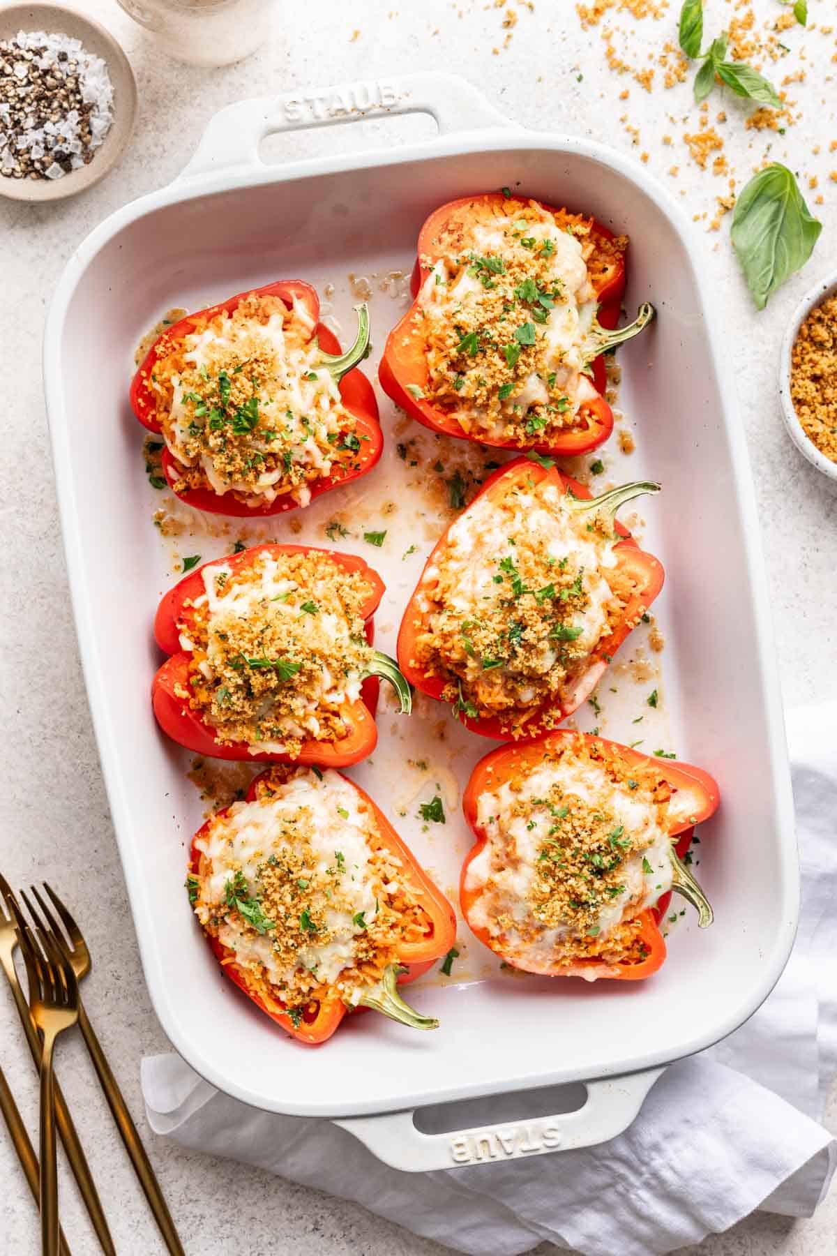 6 ground chicken stuffed peppers in a white baking dish.