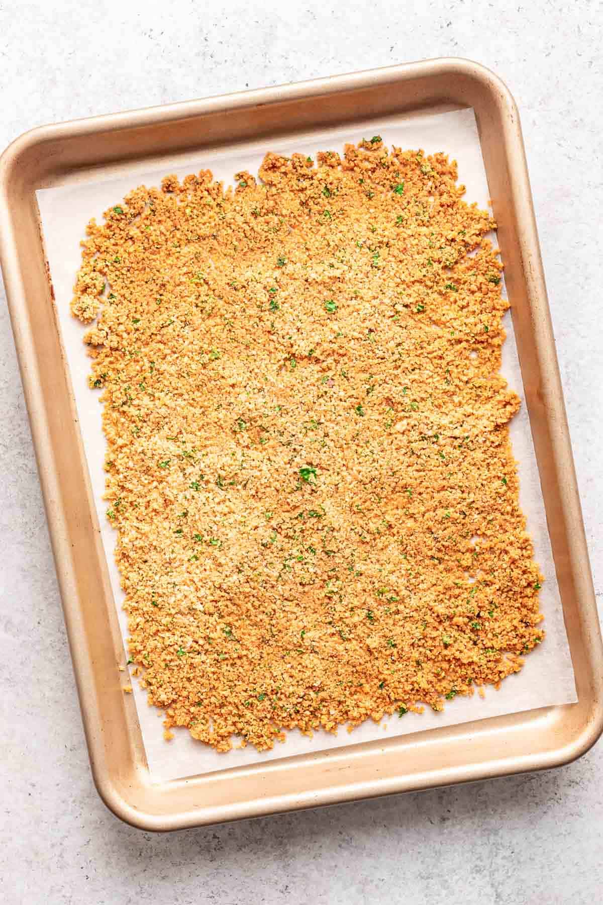 Toasted breadcrumbs on a baking sheet.