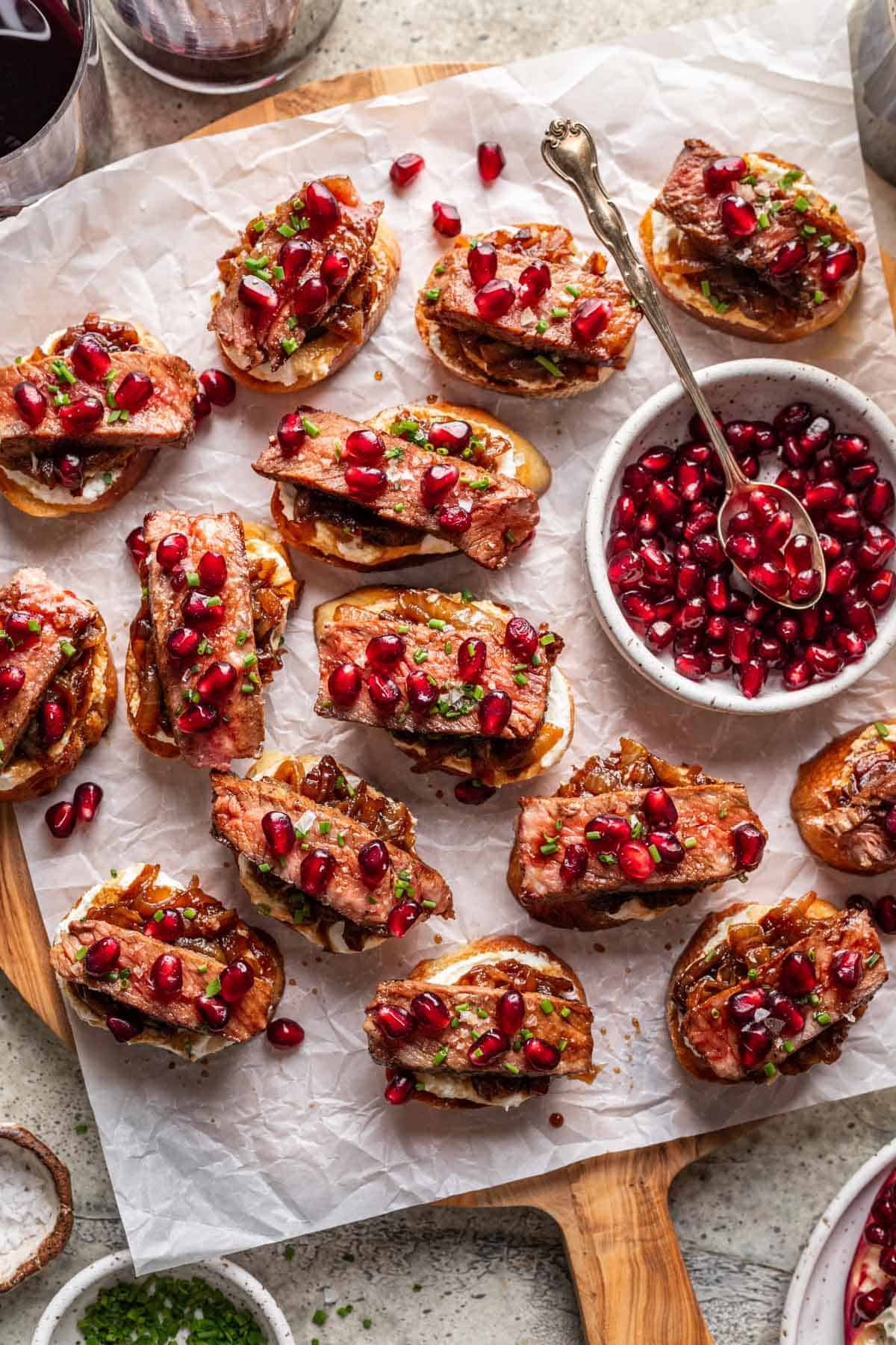Steak and whipped feta crostini on a wood serving board.