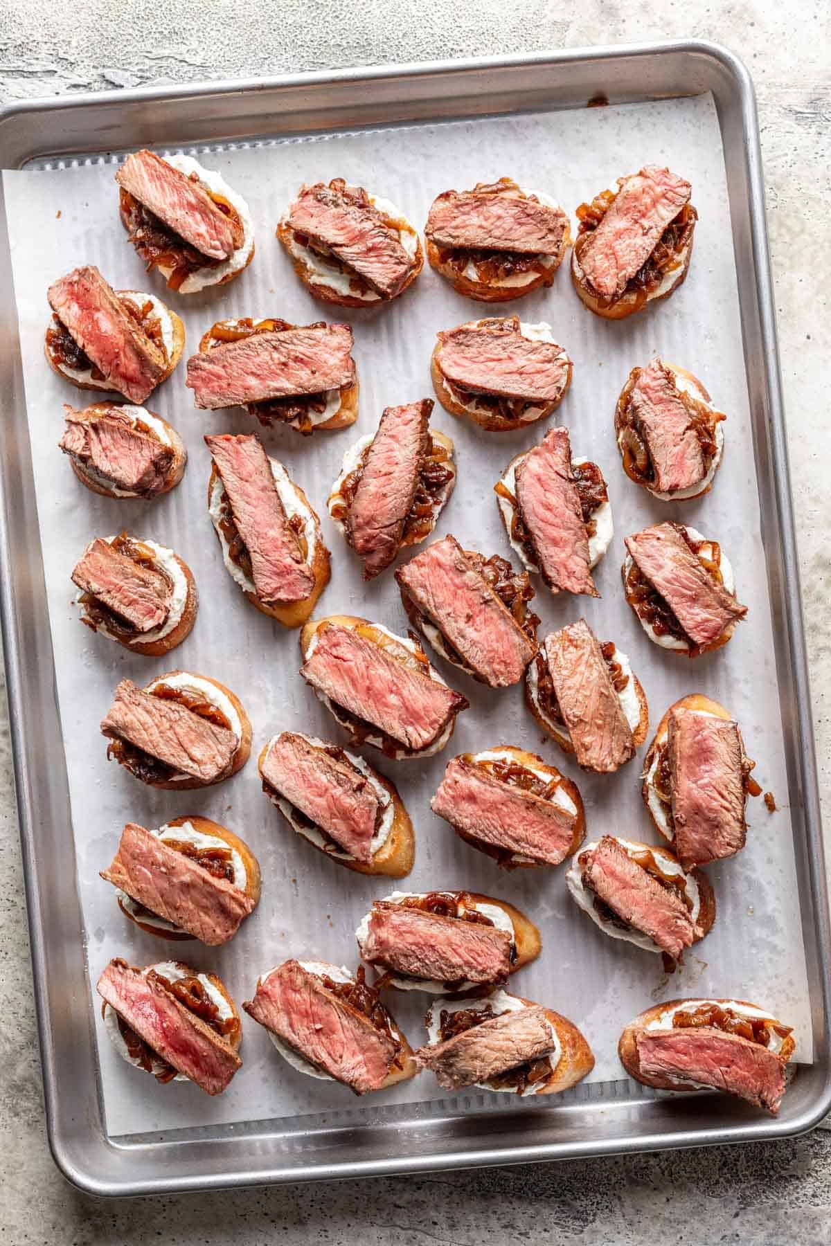 Whipped feta, caramelized onion, and a slice of steak on top of each toasted baguette.